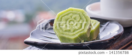 Green Asian Pastry Dessert on Black Plate with Tea Green Asian Pastry Dessert on Black Plate with Tea 141356786