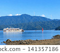 A workboat and a red lighthouse stand out against the summer sky of the Seto Inland Sea. 141357186