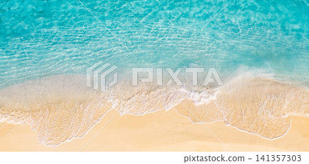 Aerial photograph of gentle waves breaking on wide sandy tropical beach. Foamy white surf lines across turquoise shallow water, textured shoreline seen from drone. Natural summer background for travel Aerial photograph of gentle waves breaking on wide sandy tropical beach. Foamy white surf lines across turquoise shallow water, textured shoreline seen from drone. Natural summer background for travel 141357303
