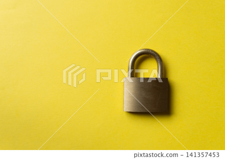 Padlock on a yellow background Padlock on a yellow background 141357453