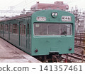 A close-up of the front of a Keihin-Tohoku Line 103 series train stopped at Tamachi Station platform during the JNR (Japanese National Railways) era. 141357461