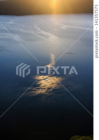 A beautiful morning scene of Lake Mashu in Hokkaido, shimmering with the soft light of the rising sun. A beautiful morning scene of Lake Mashu in Hokkaido, shimmering with the soft light of the rising sun. 141357573