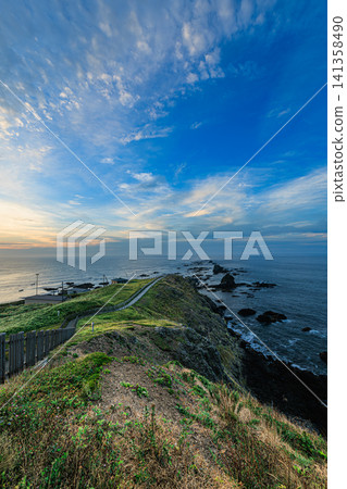 A morning view featuring clouds painted in the gradient of colors of the sunrise and a beautiful coastline. A morning view featuring clouds painted in the gradient of colors of the sunrise and a beautiful coastline. 141358490