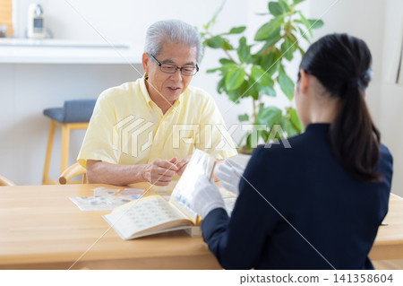 現場鑑定服務：一位老人在家中請人鑑定他的郵票和古幣。 141358604