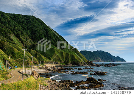 The summer scenery of the Golden Road, with its winding road and tunnels along the coastline. The summer scenery of the Golden Road, with its winding road and tunnels along the coastline. 141358779
