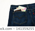 In the pants pocket of a blue denim is a smartphone and banknotes 141359255