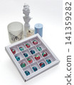 Tempered chocolate candies with glossy painted body in a box with blurred background and bokeh elements 141359282