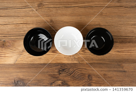 Three empty bowls on table, white porcelain, black and dishes on tabletop, rustic dish Three empty bowls on table, white porcelain, black and dishes on tabletop, rustic dish 141359670