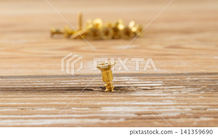 Yellow metal screws pile. Gold bolts close up 141359690