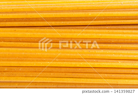 Raw wholegrain brown spaghetti macro texture, dry spagetti pattern Raw wholegrain brown spaghetti macro texture, dry spagetti pattern 141359827