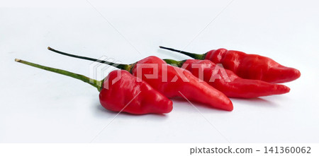 Four fresh red bird's-eye chilies arranged against a white background. Four fresh red bird's-eye chilies arranged against a white background. 141360062