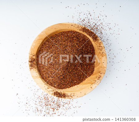 Rooibos tea leaves isolated in wood bowl Rooibos tea leaves isolated in wood bowl 141360308