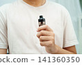 Man holding electronic cigarettes, no smoking. 141360350