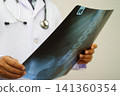 Doctor examining spine bone radiography xray film. 141360354