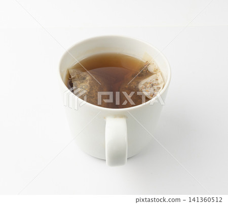 Herbal tea sachet in cup, hot water with chamomile and Hypericum or St. John's wort teabag 141360512