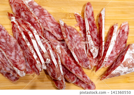 Sliced fuet sausage on wooden board closeup Sliced fuet sausage on wooden board closeup 141360550