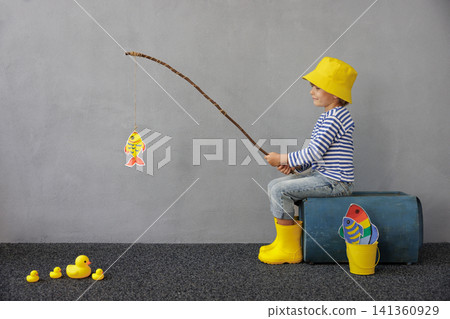 Happy child playing indoor. Kid enjoying a fishing trip. Little boy having fun at home Happy child playing indoor. Kid enjoying a fishing trip. Little boy having fun at home 141360929