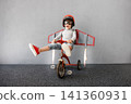 Happy child pretend to be astronaut. Funny kid with paper rocket. Little boy playing indoors 141360931