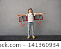 Happy child pretend to be astronaut. Funny kid with paper rocket. Little boy playing indoors 141360934
