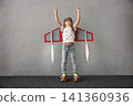 Happy child pretend to be astronaut. Funny kid with paper rocket. Little boy playing indoors 141360936