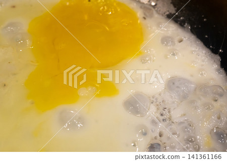 Fry eggs on pan closeup, fried cooked egg yolk and white with bubbles texture Fry eggs on pan closeup, fried cooked egg yolk and white with bubbles texture 141361166