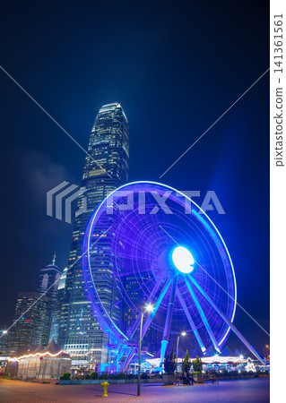 Ferris Wheel at Night with a Skyscraper in the Background in Hong Kong Ferris Wheel at Night with a Skyscraper in the Background in Hong Kong 141361561