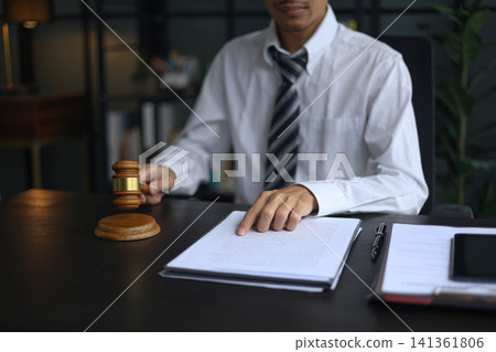 Lawyer Reviewing Contract and Documents with Gavel on Desk. 141361806