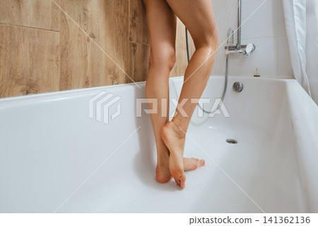Female legs in bathtub with water during shower time Female legs in bathtub with water during shower time 141362136