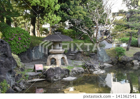 Moss-covered stone monuments and lush green trees tell the story of the garden's history. Moss-covered stone monuments and lush green trees tell the story of the garden's history. 141362541