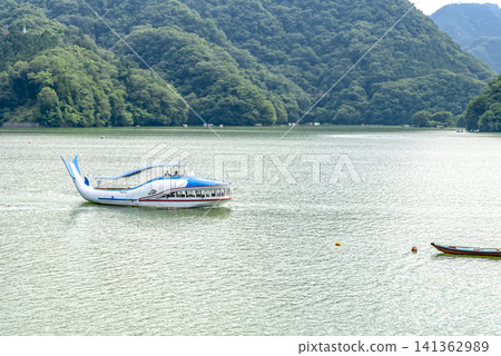 夏季,一艘觀光船航行在相模湖上,周圍環繞著鬱鬱蔥蔥的青山。 夏季,一艘觀光船航行在相模湖上,周圍環繞著鬱鬱蔥蔥的青山。 141362989