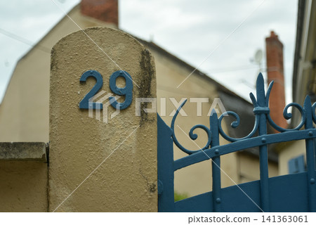 Close up view of a blue painted number 29 on a blue metal gate, showing a colorful architectural detail in an urban or residential environment. Close up view of a blue painted number 29 on a blue metal gate, showing a colorful architectural detail in an urban or residential environment. 141363061