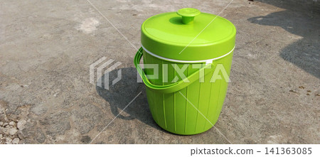 Insulated green rice container and ice bucket on a concrete surface. Insulated green rice container and ice bucket on a concrete surface. 141363085