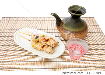 Grilled chicken skewers (chicken and green onion) seasoned with salt, served with cold sake. Grilled chicken skewers (chicken and green onion) seasoned with salt, served with cold sake. 141363093