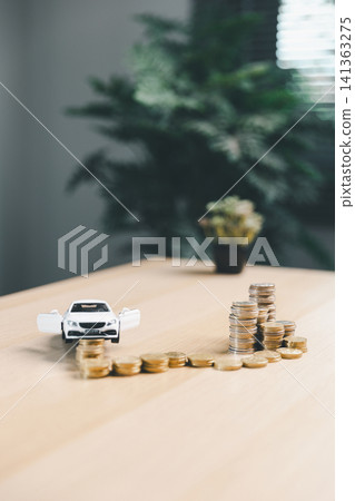 White toy car beside arranged coin stacks on desk, representing car installment growth, vehicle finance progress, savings goal, and auto ownership cost planning. White toy car beside arranged coin stacks on desk, representing car installment growth, vehicle finance progress, savings goal, and auto ownership cost planning. 141363275