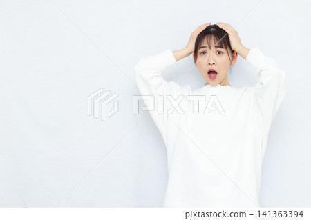 Surprised woman holding her head Surprised woman holding her head 141363394