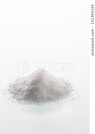 白色背景上的一堆鹽,晶瑩剔透的鹽粒閃閃發光。 白色背景上的一堆鹽,晶瑩剔透的鹽粒閃閃發光。 141364184
