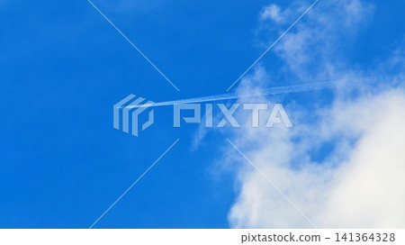 一架噴射機飛越藍天白雲。 141364328