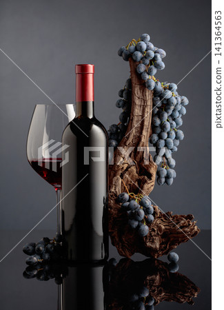 Red wine with a weathered snag and blue grapes. Red wine with a weathered snag and blue grapes. 141364563