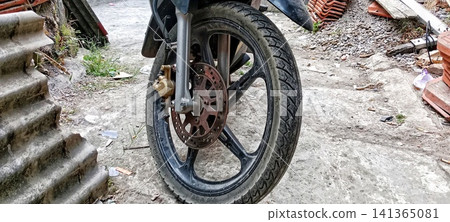 Motorcycle front wheel in the yard Motorcycle front wheel in the yard 141365081