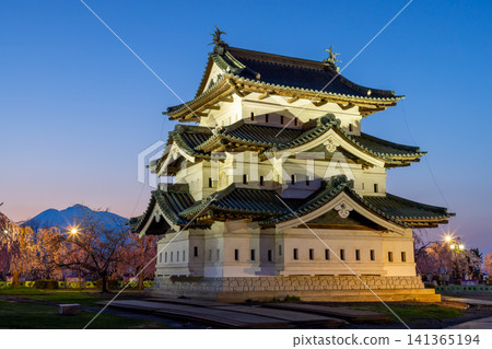 Hirosaki Park, Shimoshirogane-cho, Hirosaki City, Aomori Prefecture: Hirosaki Castle keep illuminated and the sunset over Mt. Iwaki, surrounded by cherry blossoms including weeping cherry trees. Hirosaki Park, Shimoshirogane-cho, Hirosaki City, Aomori Prefecture: Hirosaki Castle keep illuminated and the sunset over Mt. Iwaki, surrounded by cherry blossoms including weeping cherry trees. 141365194