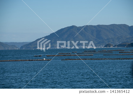 Aquaculture rafts floating in the inland sea - an image of the blue sea and sky. Aquaculture rafts floating in the inland sea - an image of the blue sea and sky. 141365412