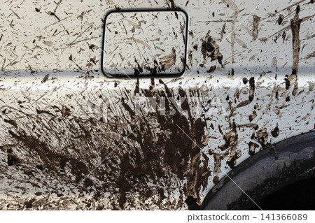 Dirty vehicle filler flap cap covered with mud splatters, wheels and tires. Closeup of a muddy car door covered in dirt.  Importance of car wash, refueling, and safe driving concept 141366089