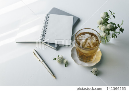 冰茶、筆記本和鋼筆。暫時放下案頭工作,沐浴在自然光中。 冰茶、筆記本和鋼筆。暫時放下案頭工作,沐浴在自然光中。 141366263