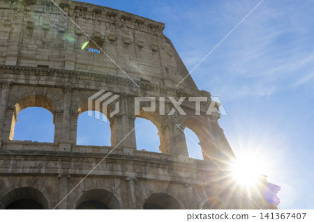 Famous Coliseum in Rome. Colosseum, or Coliseum. Sunset at huge Roman amphitheatre, Rome, Italy, Europe. Famous touristic place in the world and Europe. Beautiful blue sky background. Famous Coliseum in Rome. Colosseum, or Coliseum. Sunset at huge Roman amphitheatre, Rome, Italy, Europe. Famous touristic place in the world and Europe. Beautiful blue sky background. 141367407