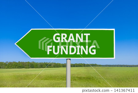 Grant funding symbol. Concept words Grant funding on beautiful green road sign. Beautiful blue sky green grass field background. Business and grant funding concept. Copy space. Grant funding symbol. Concept words Grant funding on beautiful green road sign. Beautiful blue sky green grass field background. Business and grant funding concept. Copy space. 141367411