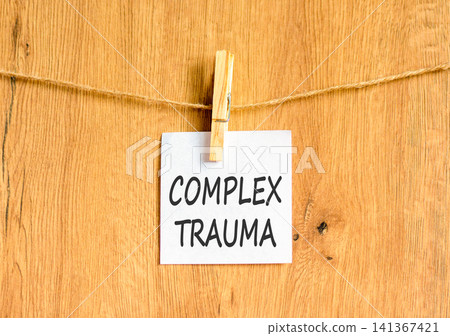 Complex trauma words symbol. Concept words Complex trauma on beautiful white paper on wooden clothespin. Beautiful wooden background. Psychological complex trauma support concept. Copy space. Complex trauma words symbol. Concept words Complex trauma on beautiful white paper on wooden clothespin. Beautiful wooden background. Psychological complex trauma support concept. Copy space. 141367421