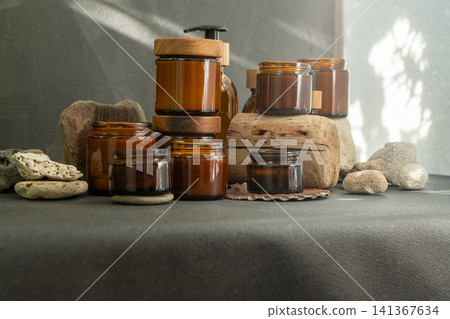 Eco-Friendly Candles Glass Cosmetic Jars and Bottles with Wooden Lids on Natural Stone and Wood Background Eco-Friendly Candles Glass Cosmetic Jars and Bottles with Wooden Lids on Natural Stone and Wood Background 141367634