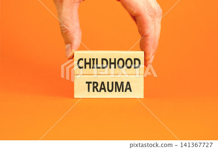 Childhood trauma words symbol. Concept words Childhood trauma on beautiful wooden blocks. Beautiful orange background. Psychologist hand. Psychological childhood trauma support concept. Copy space. 141367727
