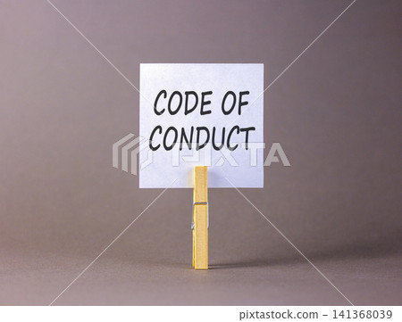 Code of conduct words symbol. Concept words Code of conduct on beautiful white paper on wooden clothespin. Beautiful grey background. Business Code of conduct concept. Copy space. Code of conduct words symbol. Concept words Code of conduct on beautiful white paper on wooden clothespin. Beautiful grey background. Business Code of conduct concept. Copy space. 141368039