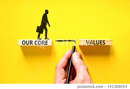 Our core values words symbol. Concept words Our core values on beautiful wooden blocks. Beautiful yellow background. Businessman hand. Business our core values motivational support concept. Copy space 141368054